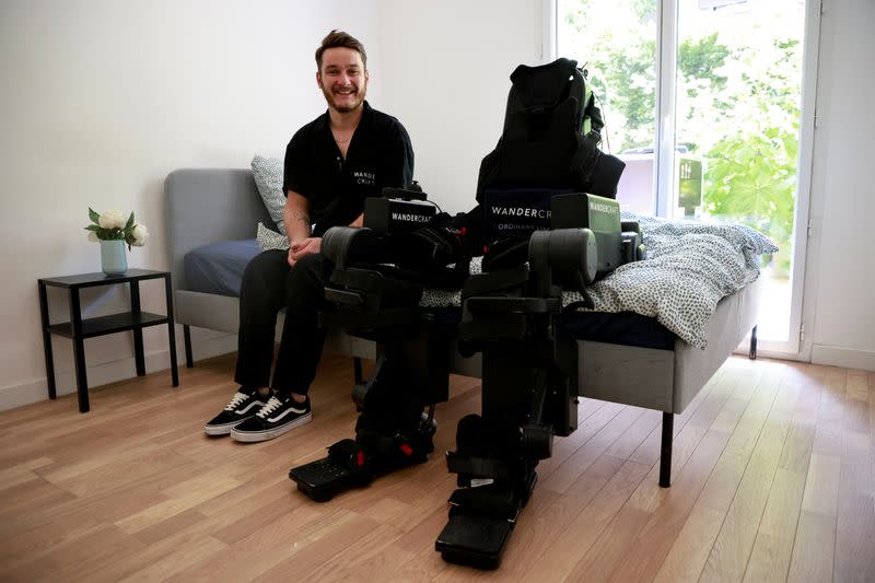 Kevin Piette posa junto a un exoesqueleto robot creado por la empresa francesa Wandercraft para ayudar a los pacientes en silla de ruedas a aprender o reaprender a caminar, durante una entrevista con Reuters en Asnieres-sur-Seine, Francia