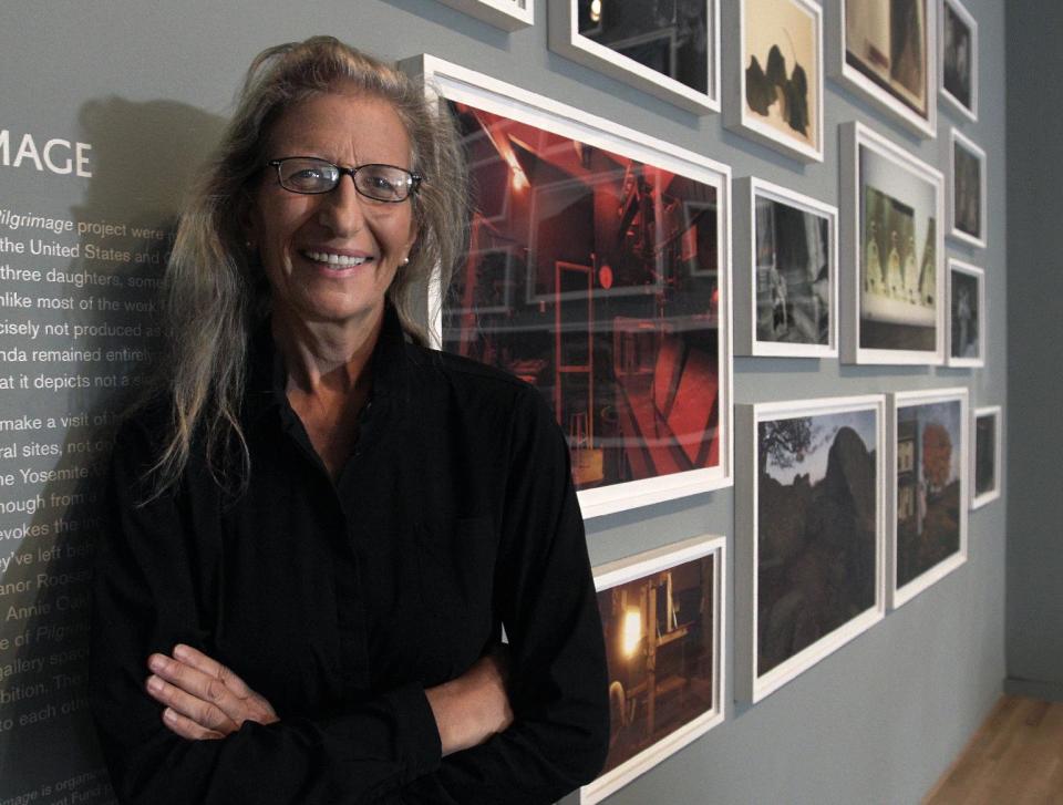 Annie Leibovitz stands near some of her work before the opening of her exhibition at the Wexner Center for the Arts Friday, Sept. 21, 2012, in Columbus, Ohio. Leibovitz's exhibition features work from her “Master Set,” an authoritative edition of 156 images. (AP Photo/Jay LaPrete)