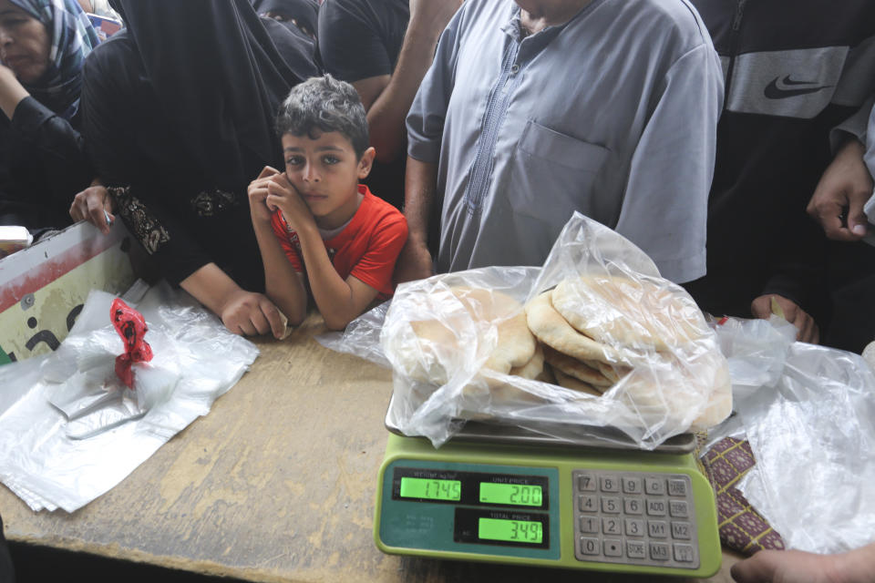 Palestinos esperan a comprar pan durante los bombardeos en la Franja de Gaza, en Rafah, el domingo 29 de octubre de 2023. (AP Foto/Hatem Ali)