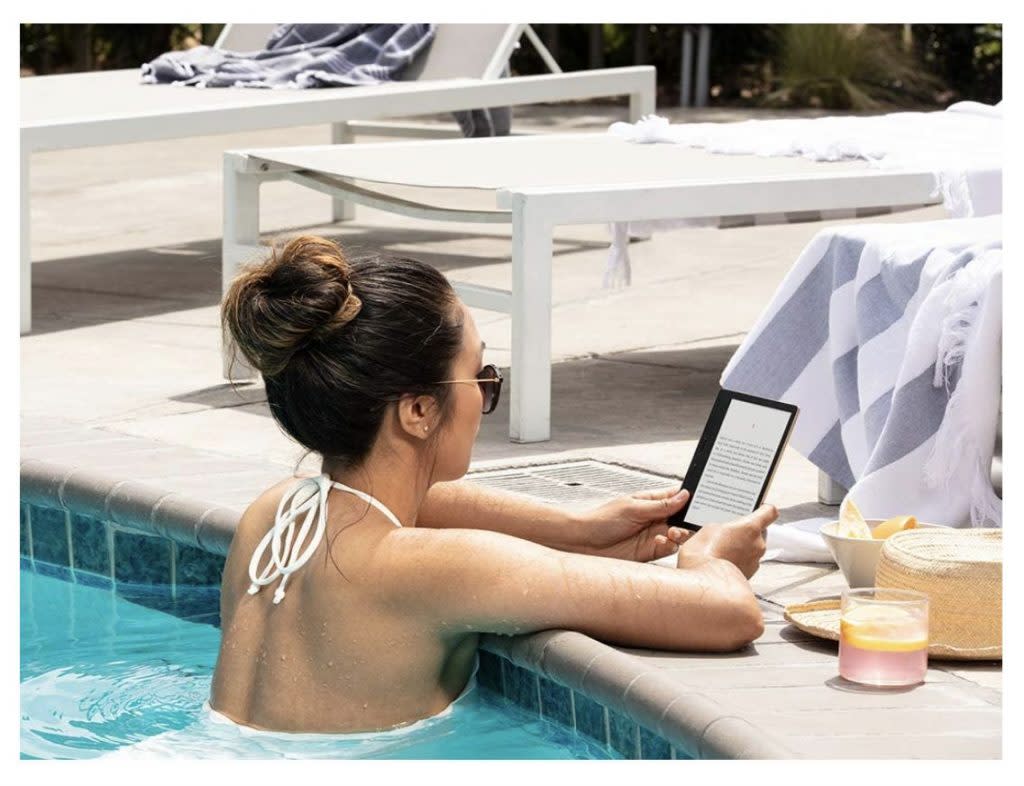 Woman reading on a waterproof Amazon Kindle in the pool while on vacation. Check out more Prime Day 2021 Kindle deals and deals on Kindle Unlimited. 