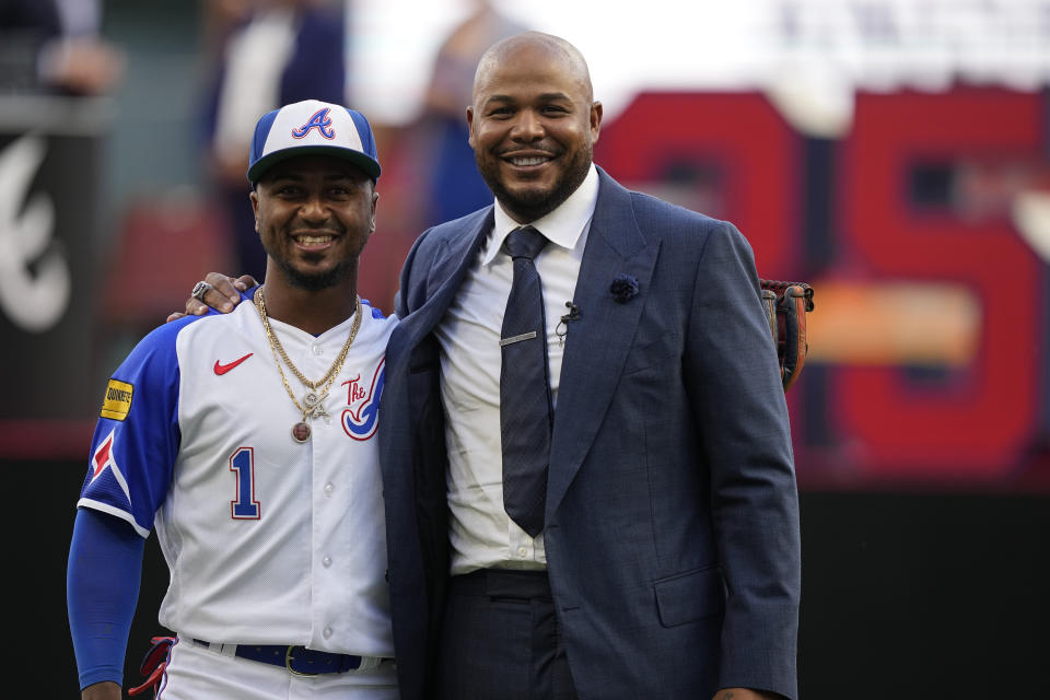 Former Atlanta Braves player, Andruw Jones poses with Atlanta Braves second baseman Ozzie Albies, on the field as he is honored, Saturday, Sept. 9, 2023, in Atlanta. Jones who won 10 Gold Gloves in a career that began with 12 seasons in Atlanta, became the 11th Braves player or manager to have his number retired on Saturday night. The honor could add momentum to his candidacy for the Baseball Hall of Fame. Jones' 25 was retired before the Braves' game against the Pittsburgh Pirates. (AP Photo/Brynn Anderson)