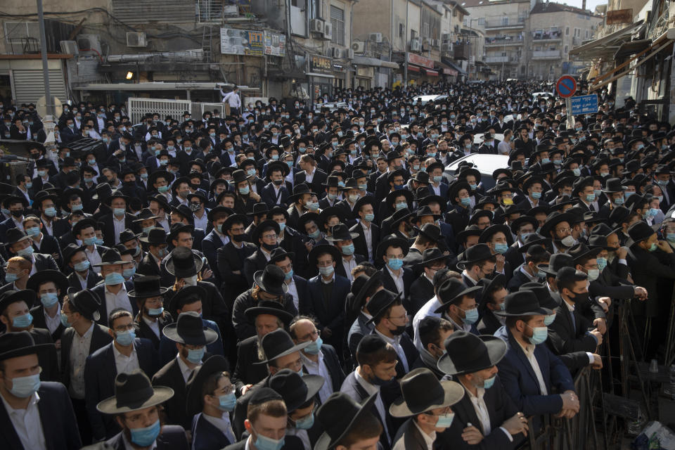 Thousands of ultra-Orthodox Jewish men attend the funeral of Rabbi Aharon David Hadash, the spiritual leader of the Mir Yeshiva, a prominent religious seminary, in Jerusalem, Thursday, Dec. 3, 2020. The mass ceremony took place despite coronavirus restrictions limiting the size of funerals. Hadash, who was 90 was hospitalized two months ago after he tested positive for COVID-19. (AP Photo/Oded Balilty)