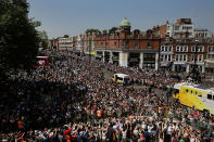 The Olympic Torch (bottom right) is carried through the crowd packed streets of central Brixton on July 26, 2012 in London, England. The Olympic flame is making its way through the capital on penultimate day of its journey around the UK before arriving in the Olympic Stadium on Friday evening for the Olympic games' Opening Ceremony. (Photo by Matthew Lloyd/Getty Images)