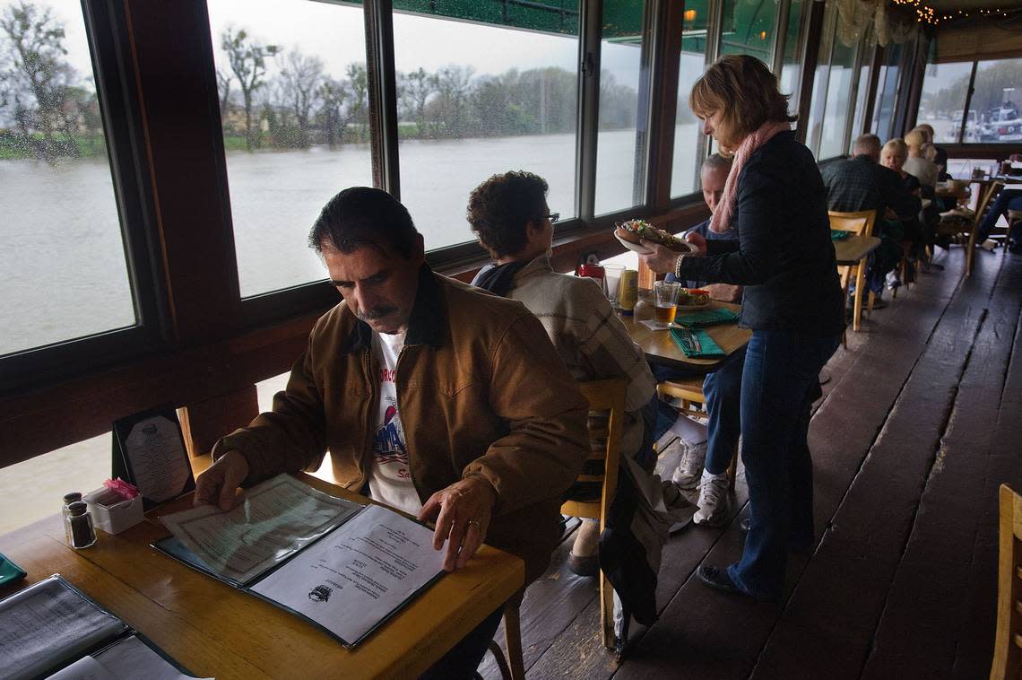 Herb Breisacher sits above the high water and peruses the menu at The Virgin Sturgeon restaurant, off Garden Highway.