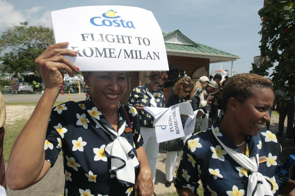 Hostesses wait for passengers of the Costa Allegra cruise ship to arrive in Victoria, Seychelles Island, Thursday, March 1, 2012. The disabled cruise ship arrived in port in the island nation of the Seychelles on Thursday morning after three days at sea without power. (AP Photo/Gregorio Borgia)