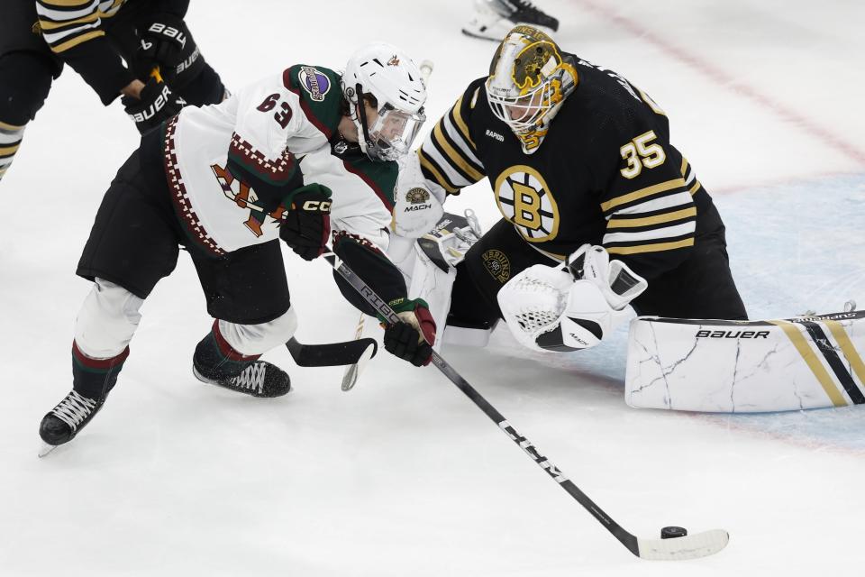 Arizona Coyotes' Matias Maccelli (63) tries to get a shot on Boston Bruins' Linus Ullmark (35) during the second period of an NHL hockey game, Saturday, Dec. 9 2023, in Boston. (AP Photo/Michael Dwyer)