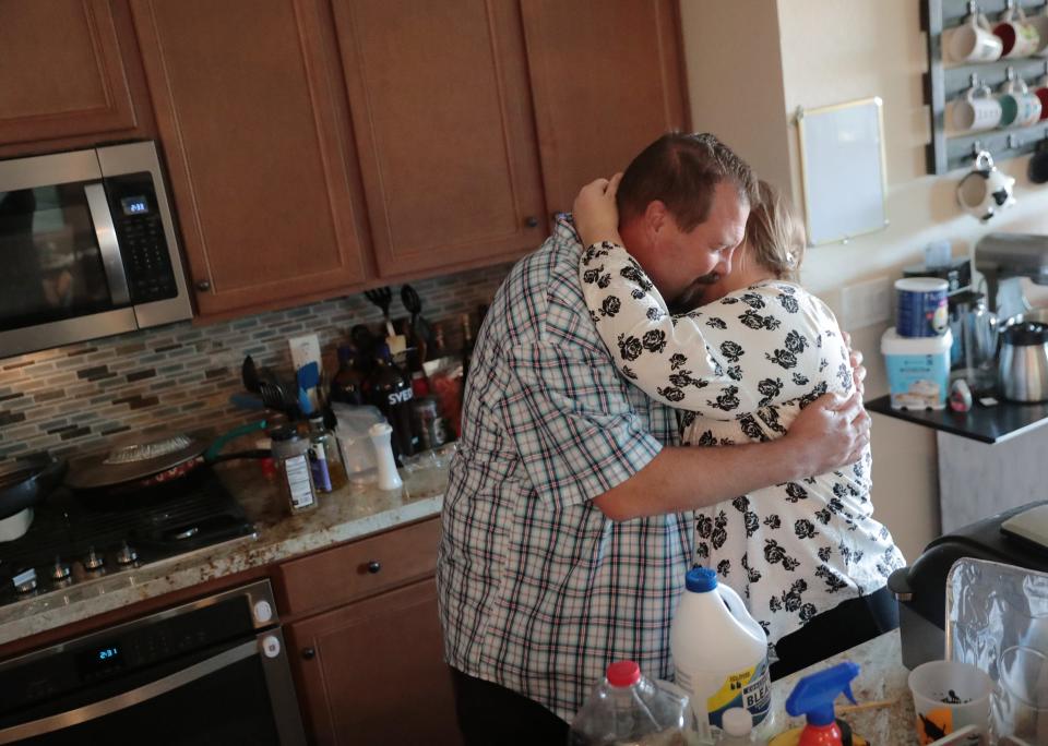 George Adair hugs his wife, Catherine, inside their Buckeye home Feb. 14, 2021. George's mother, Phyllis, was a flight attendant for American Airlines and died Feb. 2 from COVID-19.