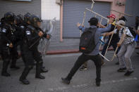 Supporters of Guatemalan President-elect Bernardo Arévalo, right, face off with police outside Congress, to protest a delay in the start of the legislative session to swear-in new lawmakers on Arévalo's inauguration Day in Guatemala City, Sunday, Jan. 14, 2024. (AP Photo/Santiago Billy)