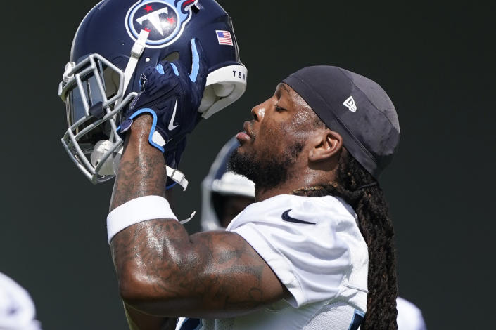 Tennessee Titans running back Derrick Henry puts on his helmet at the NFL football team's practice facility, Wednesday, June 15, 2022, in Nashville, Tenn. (AP Photo/Mark Humphrey)