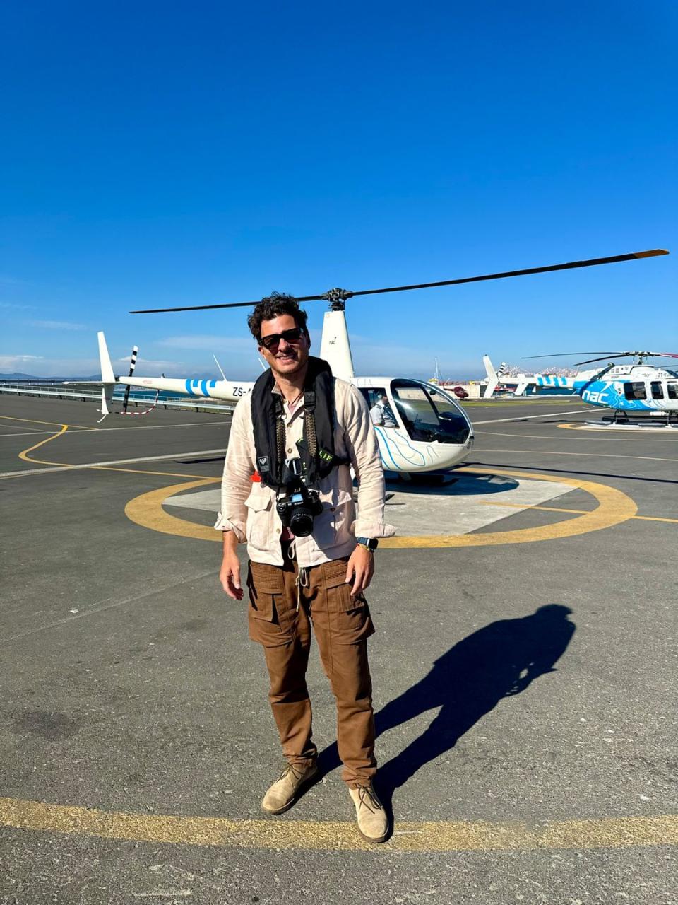 a man standing in front of a helicopter