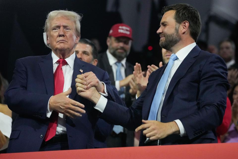 Former President Donald Trump shakes hands with Republican vice president nominee JD Vance during the first day of the Republican National Convention on July 15, 2024, in Milwaukee, Wis. The RNC kicked off the first day of the convention with the roll call vote of the states.