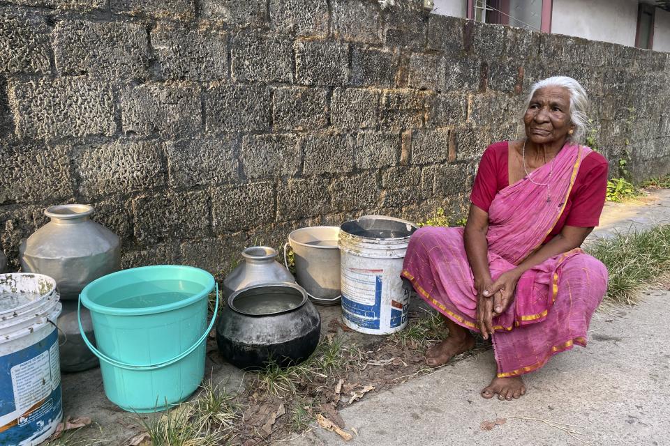 Maryamma Pillai sits near her pots after collecting water from a tanker in the Chellanam area of Kochi, Kerala state, India, March 1, 2023. Pillai is among residents who wait on a truck nearly every day to get clean water. (Uzmi Athar/Press Trust of India via AP)