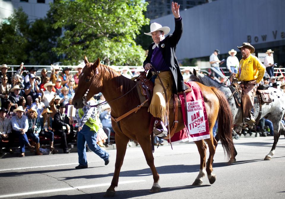 FILE - Country music legend and parade marshal Ian Tyson waves to the crowd during the Calgary Stampede parade in Calgary, Alberta, Canada, on Friday, July 6, 2012. Tyson, the Canadian folk singer who wrote the modern standard “Four Strong Winds” as one half of Ian & Sylvia and helped influence such future superstars as Joni Mitchell and Neil Young, has died at age 89. His manager, Paul Mascioli, says Tyson died Thursday, Dec. 29, 2022, at his ranch in southern Alberta following a series of health complications. (Jeff McIntosh/The Canadian Press via AP, File)