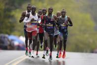 Eliud Kipchoge, of Kenya, left, Benson Kipruto, of Kenya, center, and Evans Chebet, of Kenya, right, lead a group of elite runners as make their way along the course of the 127th Boston Marathon, Monday, April 17, 2023, in Newton, Mass. (AP Photo/Steven Senne)