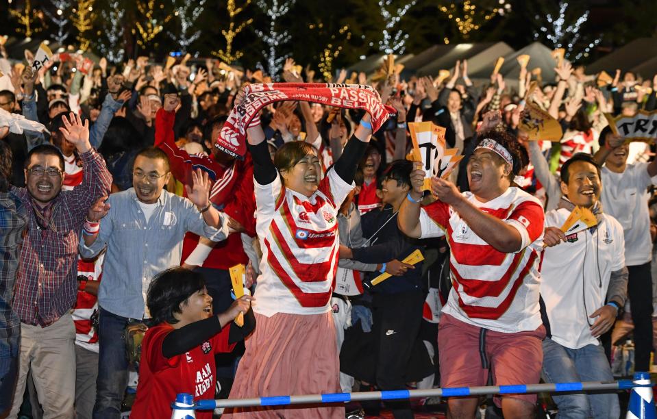 Japan team's fans celebrate the team's win over Scotland at the Rugby World Cup Pool A game as they watch the game in a public viewing in Osaka, Sunday, Oct. 13, 2019. (Kyodo News via AP)