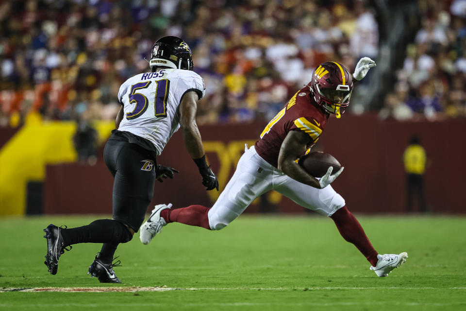 LANDOVER, MD – AUGUST 21: Antonio Gibson #24 of the Washington Commanders carries the ball as Josh Ross #51 of the Baltimore Ravens defends during the first half of the preseason game at FedExField on August 21, 2023 in Landover, Maryland. (Photo by Scott Taetsch/Getty Images)