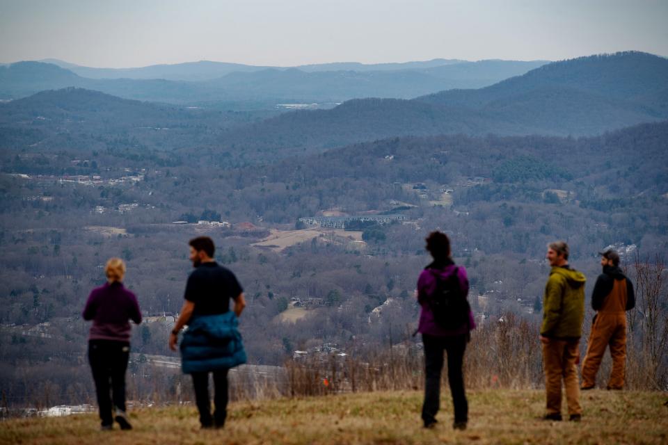 A group takes in the view of Asheville from atop Deaverview Mountain, February 16, 2024.