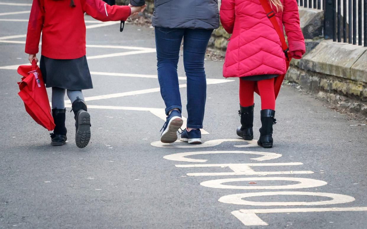 Children outside their school - Michael Gove insists teachers will be safe to return to school next month - PA