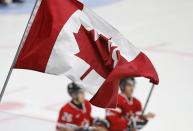 Canadian players skate during the warm-up as a supporter waves a flag before the semi-final game against Finland at the IIHF World Junior Championship ice hockey game in Malmo, Sweden, January 4, 2014. REUTERS/Alexander Demianchuk (SWEDEN - Tags: SPORT ICE HOCKEY)