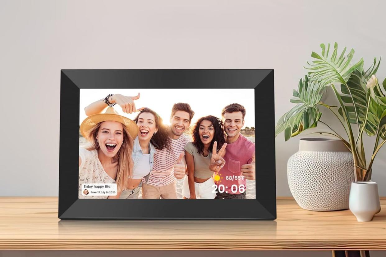 the digital picture frame from Amazon on a desk beside plants 
