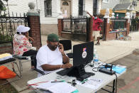 Amit Shivprasad, foreground, works outside his family home in the Queens borough of New York, Friday, Sept. 17, 2021. He and his parents have been living with a relative since floodwaters from the remnants of Hurricane Ida made their home inhospitable. Flooding collapsed part of a basement wall, allowing water to gush into a basement apartment where a woman and her grown son died. (AP Photo/Bobby Caina Calvan)