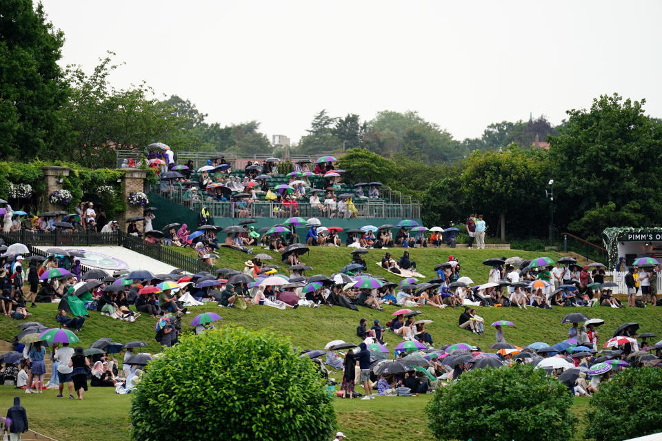 Spectators take shelter during a rain delay on day six of the 2023 Wimbledon Championships at the All England Lawn Tennis and Croquet Club in Wimbledon. Picture date: Saturday July 8, 2023. (Photo by Zac Goodwin/PA Images via Getty Images)