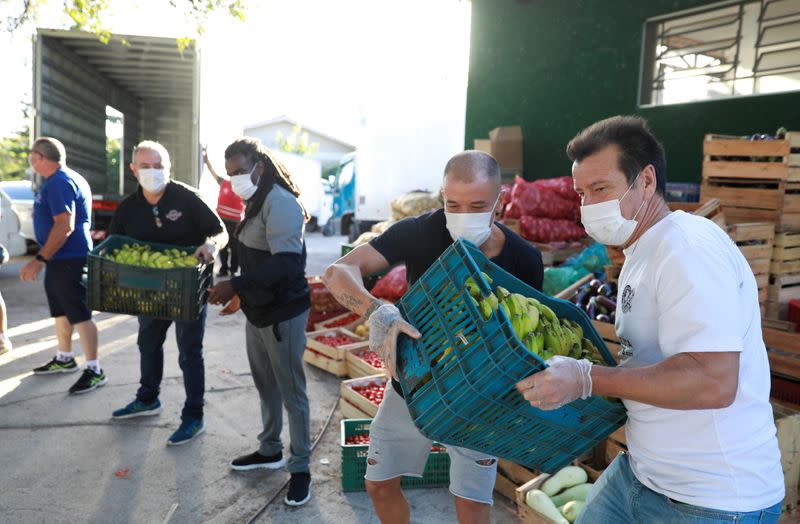 Former Brazil's head soccer coach Dunga and Internacional's soccer club player Andres D'Alessandro help with food distribution to poor people, amid the coronavirus disease (COVID-19) outbreak, in Porto Alegre