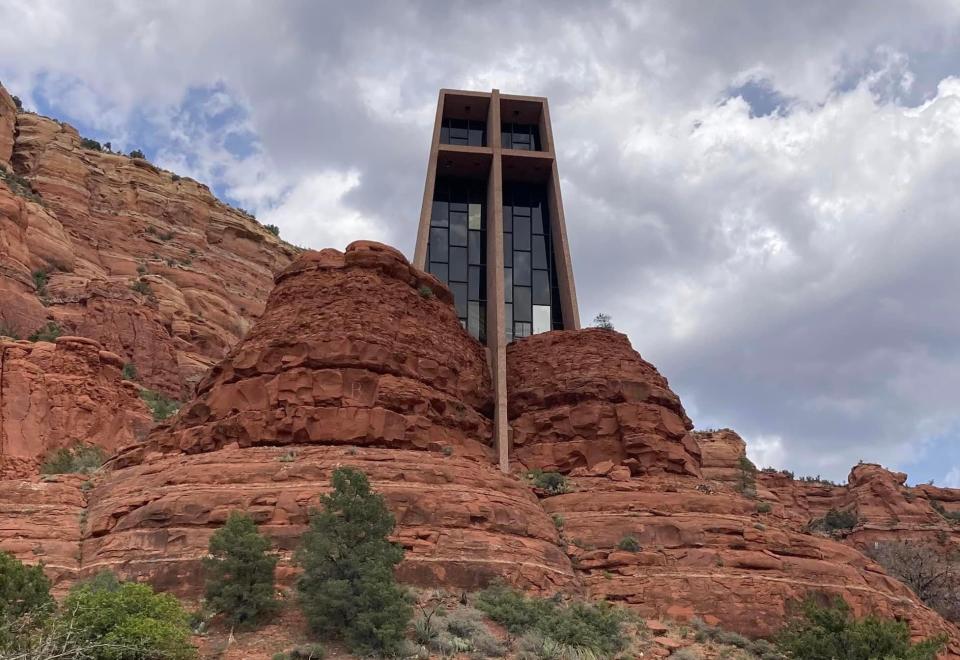 Tall church with windows built into the side of a red rock formation in Arizona