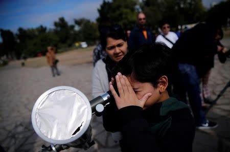 A boy uses a telescope to observe the planet Mercury transit in front of the sun outside Buenos Aires' planetarium, Argentina, May 9, 2016. REUTERS/Marcos Brindicci