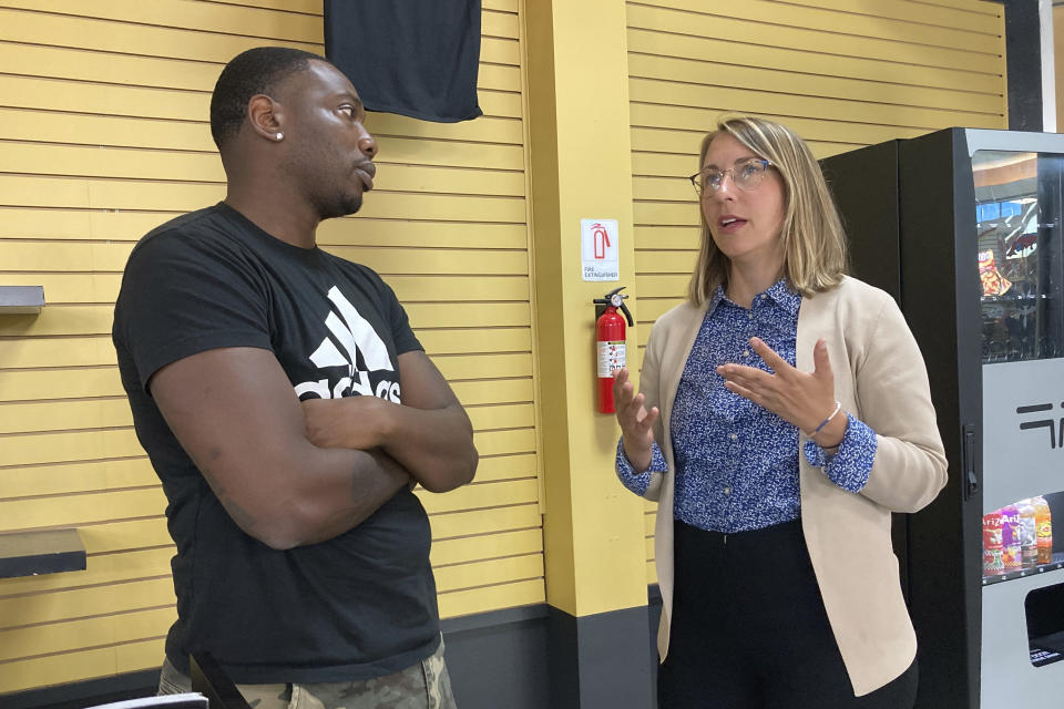 Hillary Scholten, right, the Democratic nominee for Congress in Michigan's 3rd District, speaks with business owner Darrell Gordon during a campaign stop, Tuesday, Aug. 9, 2022 in Muskegon, Mich. Scholten, a lawyer from Grand Rapids, in November will face Republican John Gibbs, a businessman and missionary who served in the Trump administration under Housing and Urban Development Secretary Ben Carson. (AP Photo/Mike Householder)