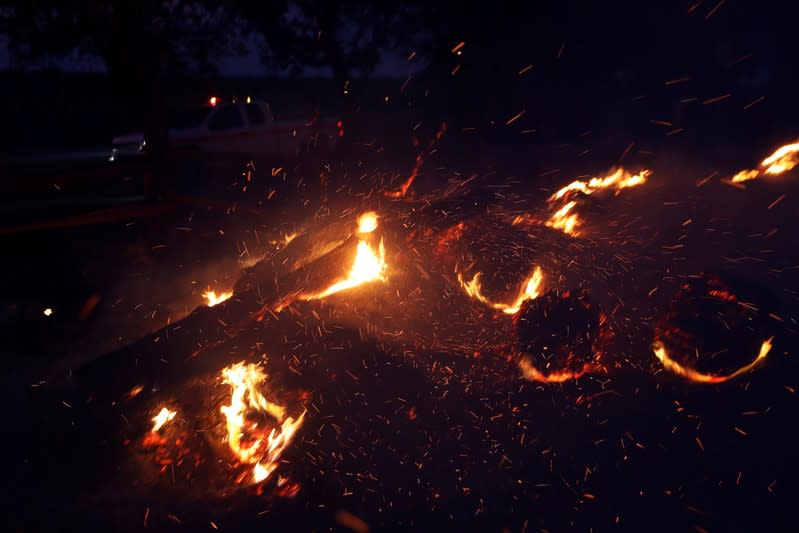 Embers fly in the air as a fire engine drives past during the wind-driven Kincade Fire in Healdsburg, California