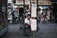 A lottery ticket seller rests at a bus stop in Athens on June 3, 2015