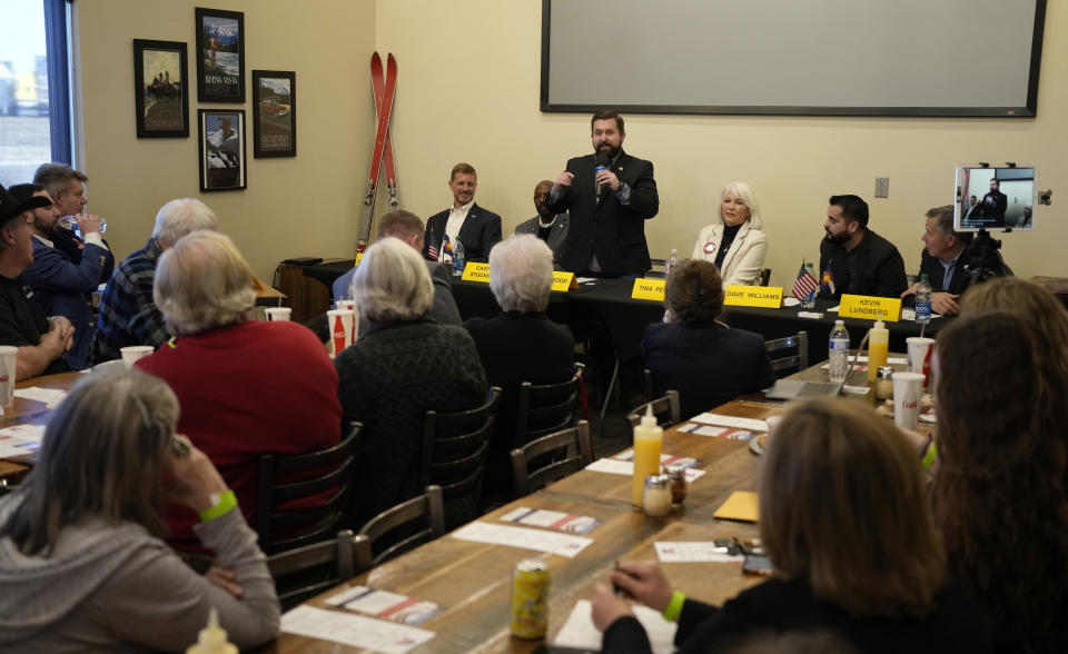 Colorado Republican party chair candidate Aaron Wood, back center, speaks as fellow candidates listen during a debate for the state Republican party leadership position Saturday, Feb. 25, 2023, in a pizza restaurant in Hudson, Colo. (AP Photo/David Zalubowski)