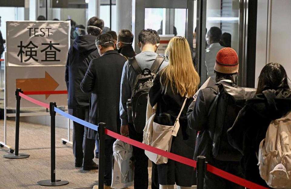 Passengers from Shanghai line up to take a higher-sensitivity COVID-19 antigen test o their arrival at Narita airport near Tokyo on Jan. 8, 2023. China is suspending issuing visas for South Koreans to come to the country for tourism or business in apparent retaliation for COVID-19-related requirements on Chinese travelers. Japan’s Kyodo News service said the ban would also affect Japanese travelers. (Kyodo News via AP)