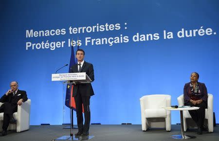 French Prime Minister Manuel Valls (C) speaks as Justice minister Christiane Taubira (R) and Interior minister Bernard Cazeneuve (L) listen during a press conference to present reform proposals, agreed by the government today, at the Elysee Palace in Paris, France, December 23, 2015. REUTERS/Eric Feferberg/Pool