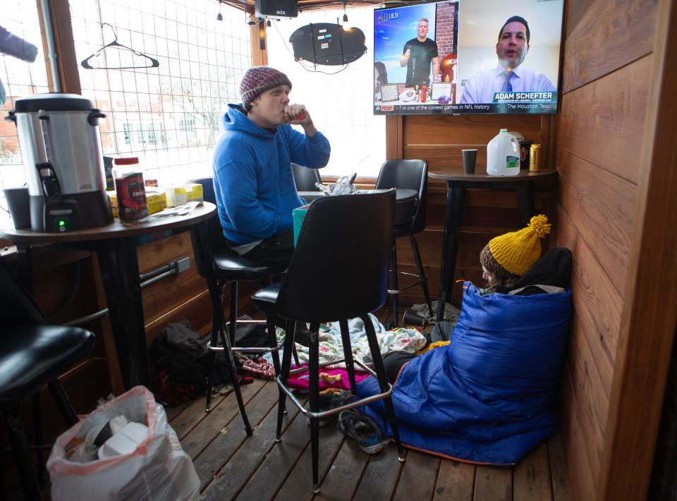 Nick Jones, left, and Max Green shelter in the outdoor seating area of Big City Gamin' in Eugene after the owners welcomed them as temperatures dipped below freezing over the holiday weekend.