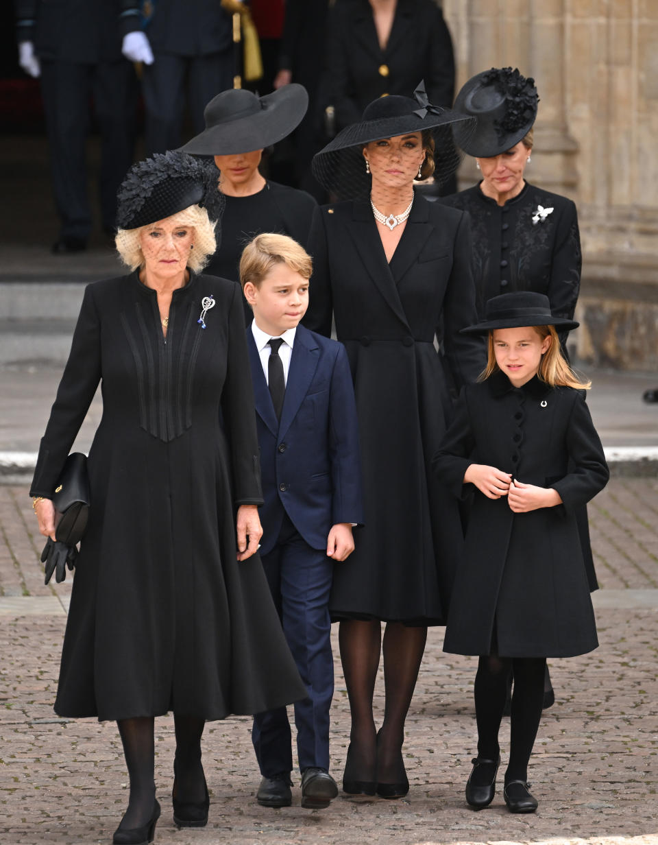 LONDON, ENGLAND - SEPTEMBER 19: (L-R) Camilla, Queen Consort, Meghan, Duchess of Sussex, Prince George of Wales, Catherine, Princess of Wales, Princess Charlotte of Wales and Sophie, Countess of Wessex during the State Funeral of Queen Elizabeth II at Westminster Abbey on September 19, 2022 in London, England. Elizabeth Alexandra Mary Windsor was born in Bruton Street, Mayfair, London on 21 April 1926. She married Prince Philip in 1947 and ascended the throne of the United Kingdom and Commonwealth on 6 February 1952 after the death of her Father, King George VI. Queen Elizabeth II died at Balmoral Castle in Scotland on September 8, 2022, and is succeeded by her eldest son, King Charles III. (Photo by Karwai Tang/WireImage)