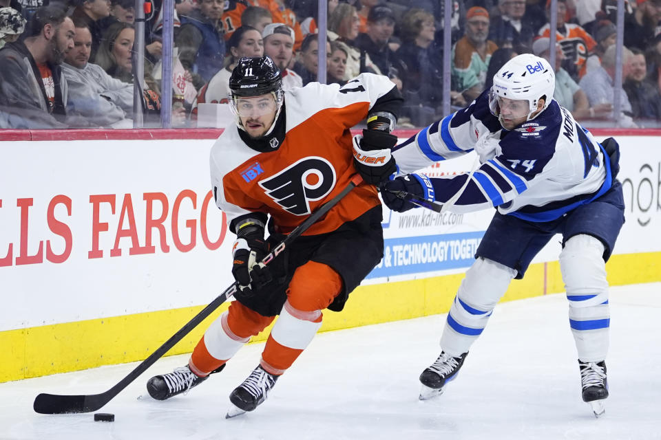 Philadelphia Flyers' Travis Konecny, left, tries to keep the puck away from Winnipeg Jets' Josh Morrissey during the second period of an NHL hockey game, Thursday, Feb. 8, 2024, in Philadelphia. (AP Photo/Matt Slocum)