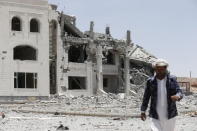 A Houthi militant walks at the yard of residence of the military commander of the Houthi militant group, Abdullah Yahya al Hakim, after an air strike destroyed it, in Sanaa April 28, 2015. REUTERS/Khaled Abdullah