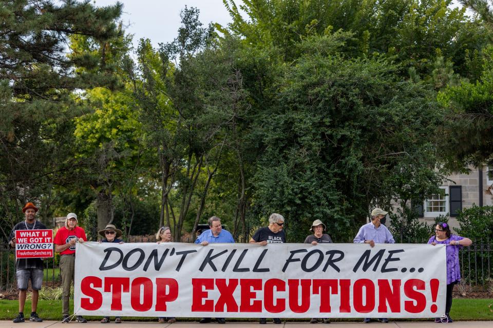 Anti-death penalty activists hold a sign with the message "Don't kill for me ... Stop executions" as they gather Thursday morning at the Governor's Mansion. Death row inmate Anthony Sanchez was executed and declared dead at 10:19 a.m. at the Oklahoma State Penitentiary in McAlester.