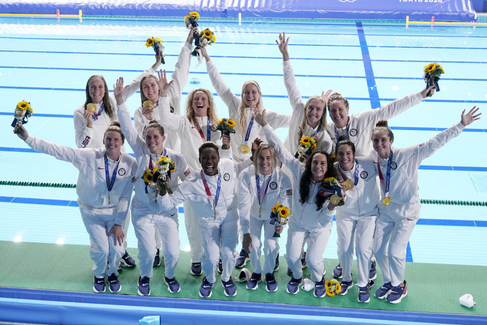 The United States women's water polo team poses with their gold medals after defeating Spain at the 2020 Summer Olympics, Saturday, Aug. 7, 2021, in Tokyo, Japan. (AP Photo/Mark Humphrey)