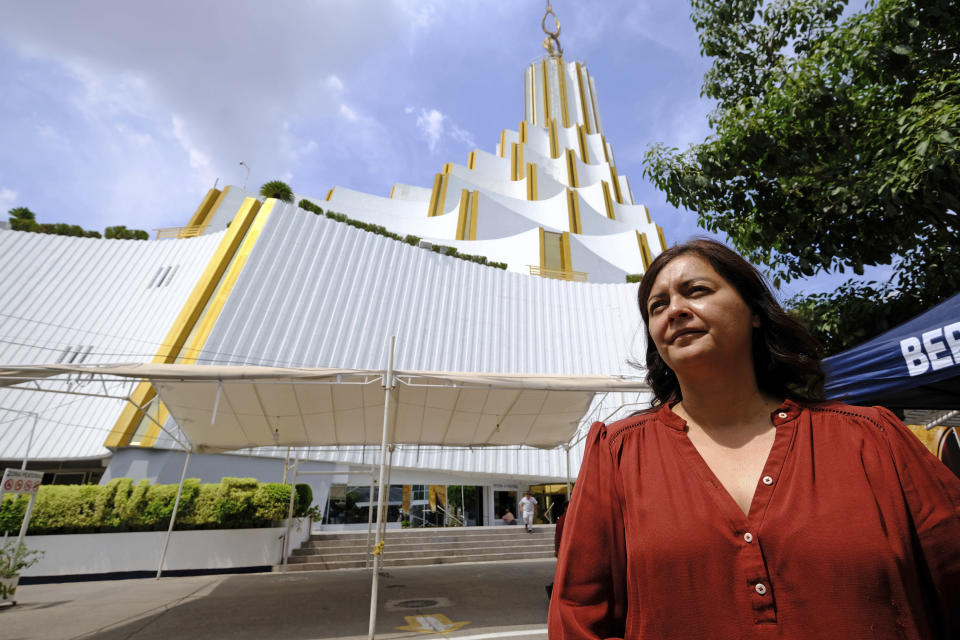 Congregant Sara Pozos stands outside the La Luz del Mundo, Spanish for The Light of the World, church’s home base, during an interview in the Hermosa Provincia neighborhood of Guadalajara, Mexico, Saturday, Aug. 13, 2022. Bethlehem and Nazareth are among the names of roads converging on the white temple that locals call “the cake,” for its white tiers that diminish in size as they rise upward. (AP Photo/Refugio Ruiz)
