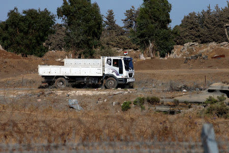 A truck with the Syrian flag is seen in Quneitra, on the Syrian side of the ceasefire line between Israel and Syria, as seen from the Israeli-occupied Golan Heights, July 26, 2018. REUTERS/Ammar Awad