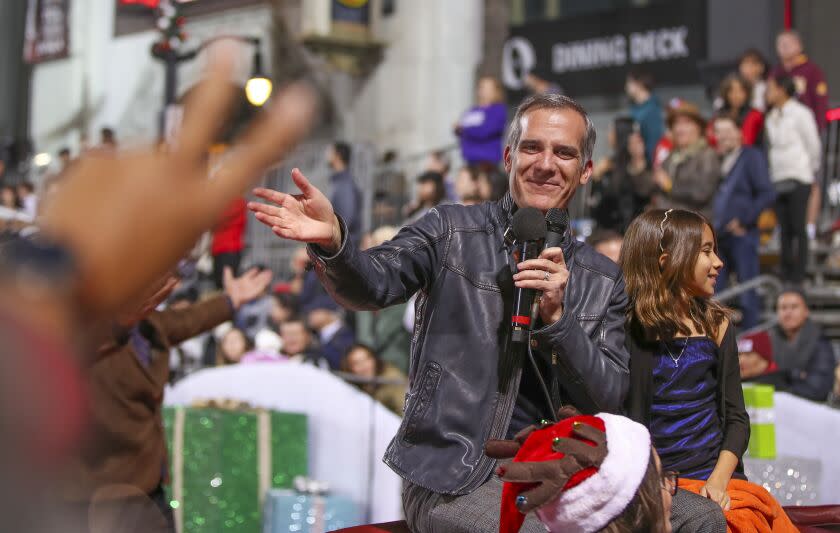 Hollywood, CA - November 27: A person gives outgoing Los Angeles Mayor Eric Garcetti, shown with daughter, Maya Juanita Garcetti, the peace sign while riding in The 90th anniversary Hollywood Christmas Parade in Hollywood Sunday, Nov. 27, 2022. (Allen J. Schaben / Los Angeles Times) Actor Danny Trejo served as grand marshal of the parade, which will also feature dozens of movie and TV stars and other celebrities, movie and novelty cars, balloons, marching bands and city officials. Parade hosts include Erik Estrada, Laura McKenzie, Dean Cain, Montel Williams, special co-host Elizabeth Stanton.