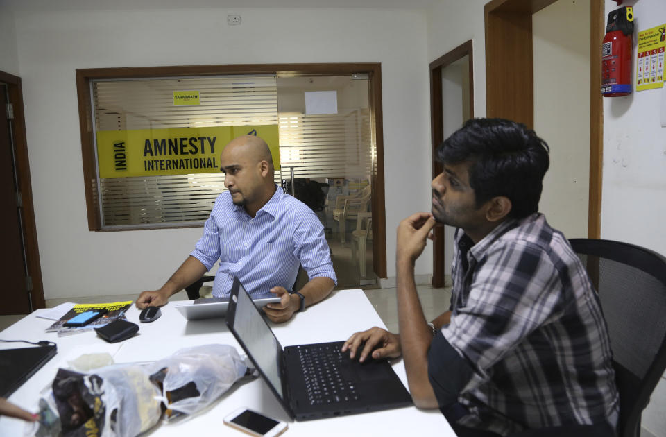 FILE - In this Tuesday, Feb. 5, 2019, file photo, Amnesty International India employees work at their headquarters in Bangalore, India. The Human rights watchdog said on Tuesday, Sept. 29, 2020, that it was halting its operation in India, citing reprisals from the government and the freezing of its bank accounts. Its announcement comes at a time amid growing concerns over the state of free speech in India where critics accuse Prime Minister Narendra Modi and his Hindu nationalist government of increasingly brandishing laws to silence human rights activists, intellectuals, filmmakers, students and journalists. (AP Photo/Aijaz Rahi, File)