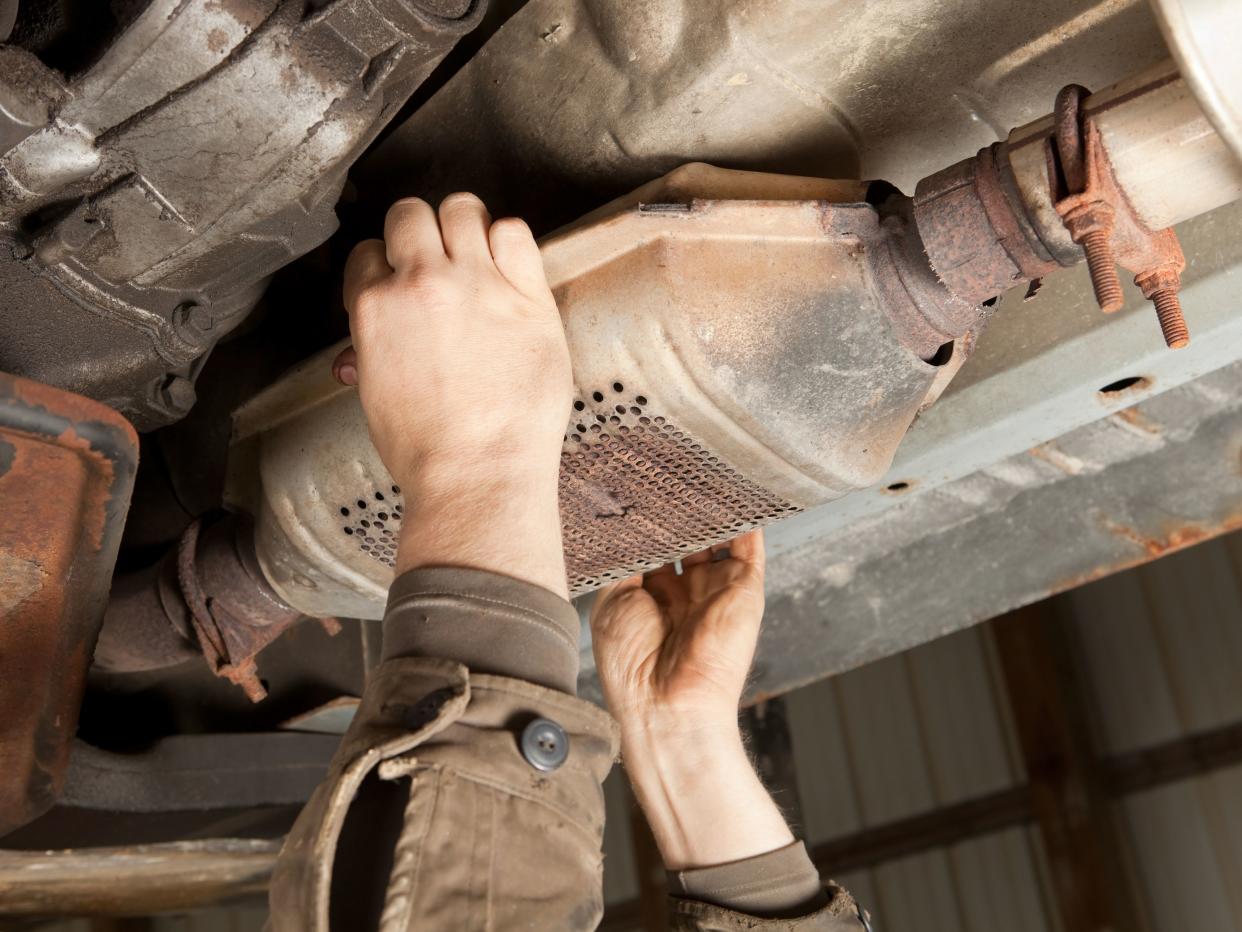 Catalytic Converter Removal at a Salvage Yard stock photo