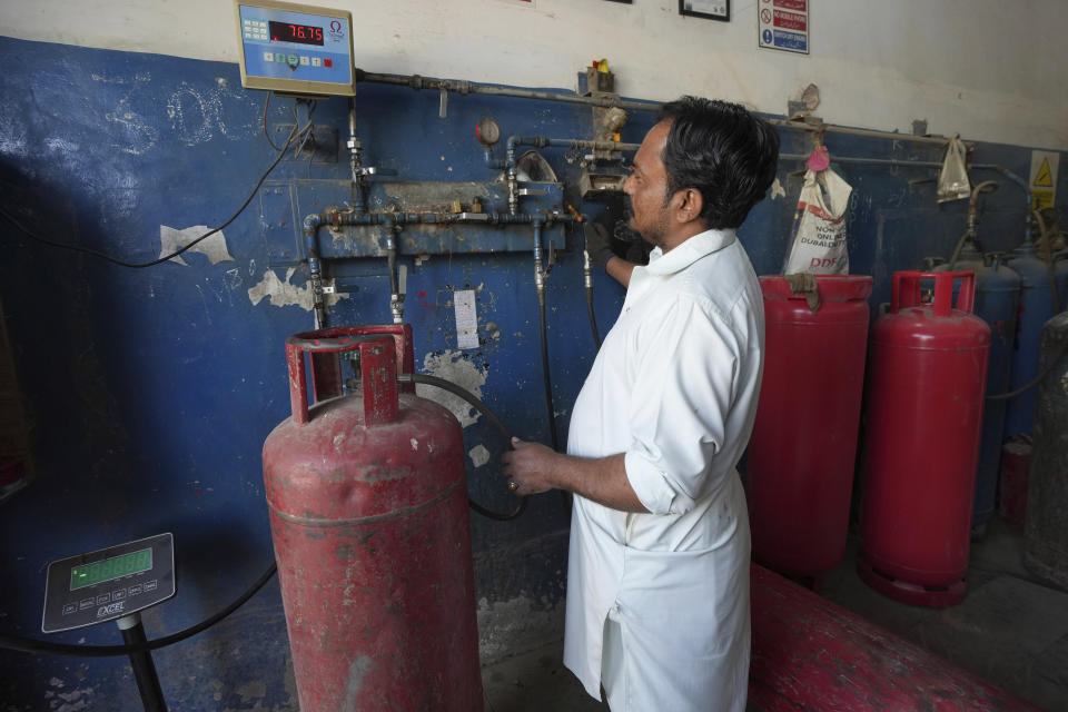 A vendor fills gas cylinder at a shop, in Karachi, Pakistan, in Karachi, Pakistan, Tuesday, Feb. 14, 2023. Cash-strapped Pakistan nearly doubled natural gas taxes Tuesday in an effort to comply with a long-stalled financial bailout, raising concerns about the hardship that could be passed on to consumers in the impoverished south Asian country. Pakistan's move came as the country struggles with instability stemming from an economic crisis. (AP Photo/Fareed Khan)