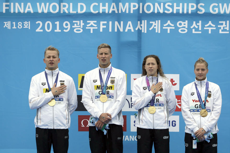 Members of the gold medal-winning team from Germany stand with their medals after the 5km mixed relay open water swim at the World Swimming Championships in Yeosu, South Korea, Thursday, July 18, 2019. (AP Photo/Mark Schiefelbein)