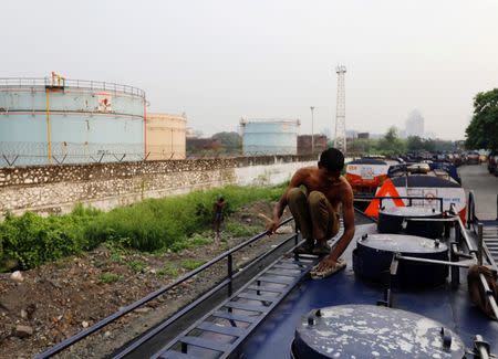 A man cleans an oil tanker parked outside a Hindustan Petroleum fuel depot in Mumbai, October 6, 2017. REUTERS/ Danish Siddiqui/Files