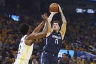 Dallas Mavericks guard Luka Doncic (77) shoots against Golden State Warriors forward Andrew Wiggins during the first half of Game 2 of the NBA basketball playoffs Western Conference finals in San Francisco, Friday, May 20, 2022. (AP Photo/Jed Jacobsohn)